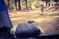 Sleeping bag in front of blonde camper walking away Royalty Free Stock Photo