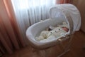 Sleeping beautiful 2 month old baby girl in a white knitted suit lies in her white crib