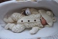 Sleeping beautiful 2 month old baby girl in a white knitted suit lies in her white crib