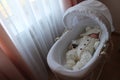 Sleeping beautiful 2 month old baby girl in a white knitted suit lies in her white crib