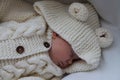 Sleeping beautiful 2 month old baby girl in a white knitted suit lies in her white crib Royalty Free Stock Photo