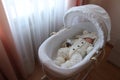 Sleeping beautiful 2 month old baby girl in a white knitted suit lies in her white crib