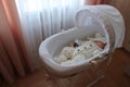 Sleeping beautiful 2 month old baby girl in a white knitted suit lies in her white crib