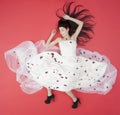 Lying beauty bride in white dress isolated on red