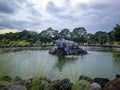 Sleeping Bull Statue In The Middle Of The Pond In The Garden Of The Park