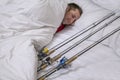 Sleeping fisherman in bed with fishing tackles. Think and dream about big fish trophy