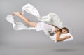 Sleeping girl. Flying in a dream. White linen flying through the air. Royalty Free Stock Photo