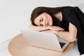 Sleeping girl with laptop on the table on white background. Tired young woman have a break at work and sleeping and Royalty Free Stock Photo