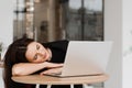 Sleeping girl with laptop on the table on white background. Tired young woman have a break at work and sleeping and Royalty Free Stock Photo