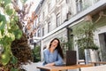 Sleeping girl with laptop is yawning outdoor on terrace in cafe. Tired young woman have a break at work and sleeping and Royalty Free Stock Photo