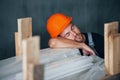 Sleeping on a job. Taking a break. Industrial worker indoors in factory. Young technician with orange hard hat Royalty Free Stock Photo