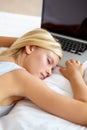 Sleeping, laptop and woman on bed tired from remote work, research and online learning in bedroom. Education, stress and