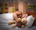 Sleeping man in bed with toy bear Royalty Free Stock Photo