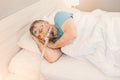 Sleeping man with chronic breathing issues considers using CPAP machine in bed. Royalty Free Stock Photo