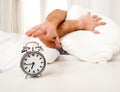 Sleeping man disturbed by alarm clock early mornin Royalty Free Stock Photo