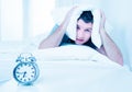 Sleeping man disturbed by alarm clock early mornin Royalty Free Stock Photo