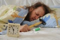 Funny sleeping man with hammer and headache pills and alarm clock in front of him Royalty Free Stock Photo