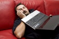 Sleeping man holding laptop Royalty Free Stock Photo