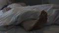 Sleeping man scratching his feet, nasty smell and discomfort due to foot fungus