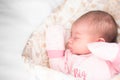 Sleeping newborn baby. Cute little girl 4 days old. Adorable lying on side with gloves