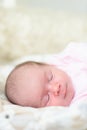 Sleeping newborn baby. Cute little girl one week old. Adorable lying on side covered with blanket