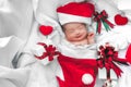 Sleeping newborn baby face in Christmas hat with gift box from S