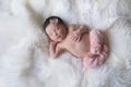 Newborn Baby Girl Sleeping on White Sheepskin Rug