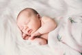 Sleeping newborn baby in a wrap on white blanket. Royalty Free Stock Photo