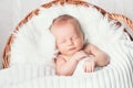 Sleeping newborn baby in a wrap on white blanket. Royalty Free Stock Photo