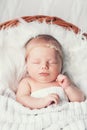 Sleeping newborn baby in a wrap on white blanket. Royalty Free Stock Photo