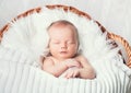 Sleeping newborn baby in a wrap on white blanket. Royalty Free Stock Photo