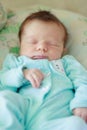 Sleeping newborn in a pajama, soft focus background