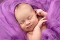 Sleeping newborn girl on a pink wool background, close-up