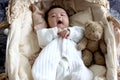 Sleeping newborn infant baby boy lying down on beautiful crib basket on bed, little cute child sleeping, lovely little kid yawning Royalty Free Stock Photo