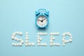 Sleeping pills and an alarm clock, insomnia concept. Trouble falling asleep Royalty Free Stock Photo