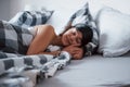 Sleeping with pleasure. Woman with blindfold mask for a sleep is lying on the bed at morning time