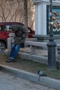 St. Petersburg, Russia, April 2019. Sleeping poor man and sleeping dove at the threshold of a Chinese restaurant.