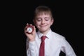 Sleeping schoolboy with a red alarm clock in his hands. Morning concept. Black background. Isolate Royalty Free Stock Photo