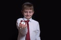 Sleeping schoolboy with a red alarm clock in his hands. Morning concept. Black background. Isolate Royalty Free Stock Photo