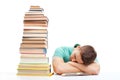 Sleeping student sitting at the desk with high books stack Royalty Free Stock Photo
