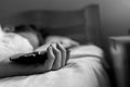 Sleeping teenage boy holding hes smartphone, conceptual image of smartphone addiction