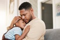 Sleeping and tired child with caring father holding his sleepy son on a home lounge sofa. Worried dad hugging his young Royalty Free Stock Photo