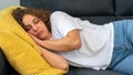 Sleeping woman with curly hair taking nap on sofa during the day at apartment Royalty Free Stock Photo