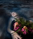 Sleeping woman in a dark water of a river