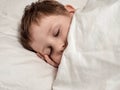 Sleeping young boy in white bed Royalty Free Stock Photo