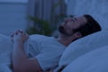 Sleepless guy laying in bed at night, thinking about something Royalty Free Stock Photo