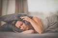 Sleepless lady covering ears with pillow Royalty Free Stock Photo