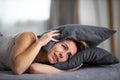 Sleepless lady covering ears with pillow Royalty Free Stock Photo