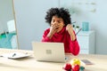 Sleepy african american woman sitting at table with laptop and yawning. Tired overworked girl lazy to work. Student Royalty Free Stock Photo