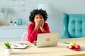 Sleepy african american woman sitting at table with laptop and yawning. Tired overworked girl lazy to work. Student Royalty Free Stock Photo